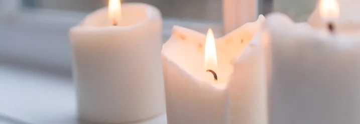 Drei brennende Kerzen auf Fensterbank